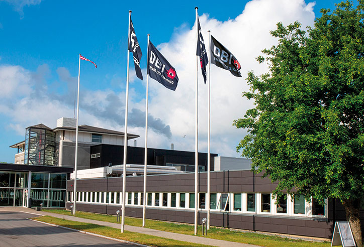 DBI Certifications hovedkontor med DBI-flag og dansk flag foran bygningen.